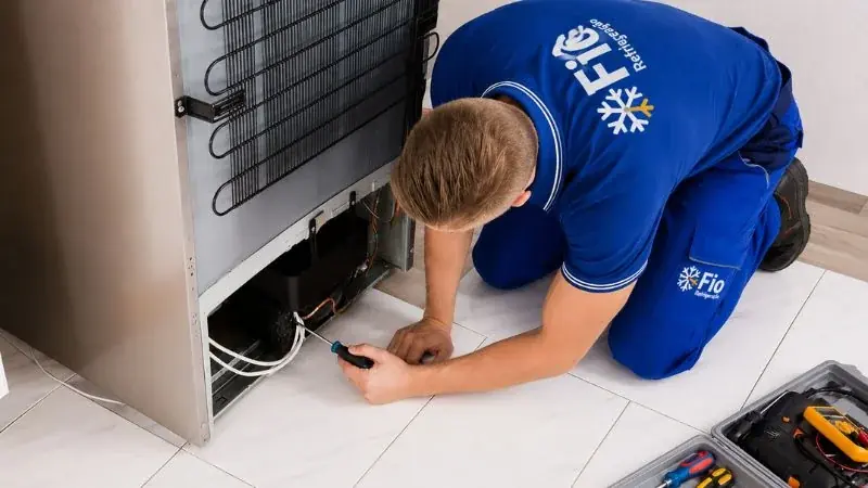 Técnico avaliando ventilação e componentes traseiros da geladeira